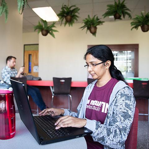 学生们在梅纳德大楼用电脑工作.