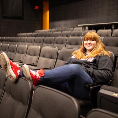 Theatre student sitting in the theatre seats